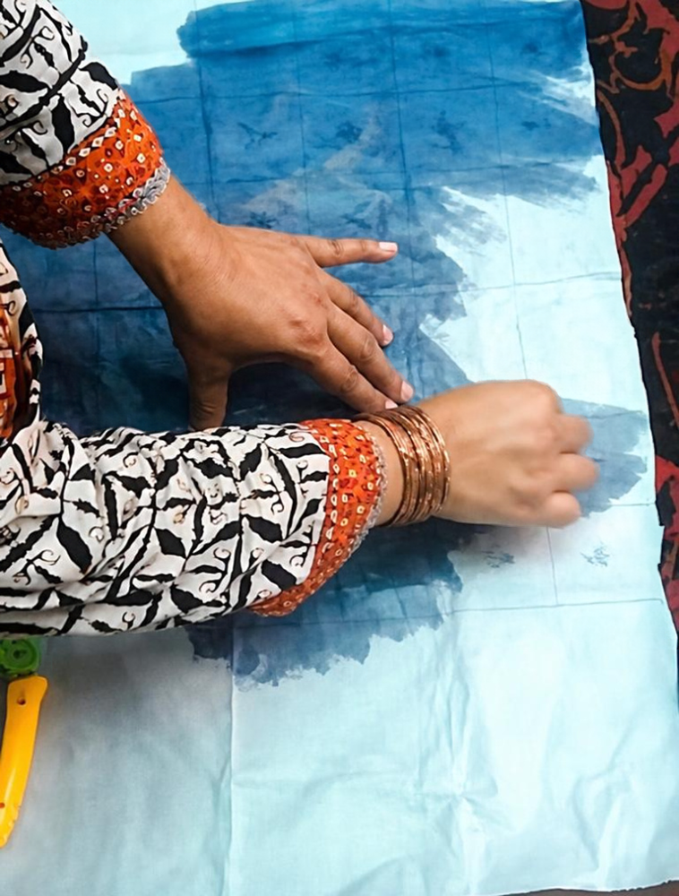 Hands transferring a pattern onto fabric